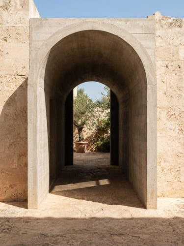 Minimalist architectural concrete archway, bright natural daylight casting sharp geometric shadows on warm beige stone, high-end architectural photography