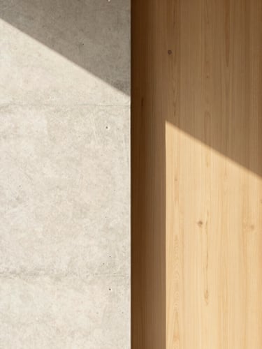 Portrait architectural detail of a raw concrete wall meeting warm oak paneling, soft morning light casting geometric shadows, minimalist composition