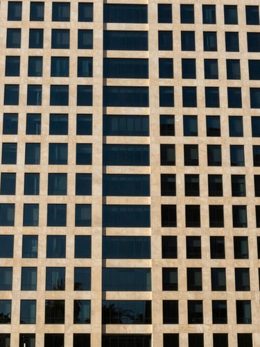 Sharp editorial photography of modern corporate architectural facade in Dubai, bright daylight, deep navy shadows, crisp 35mm lens
