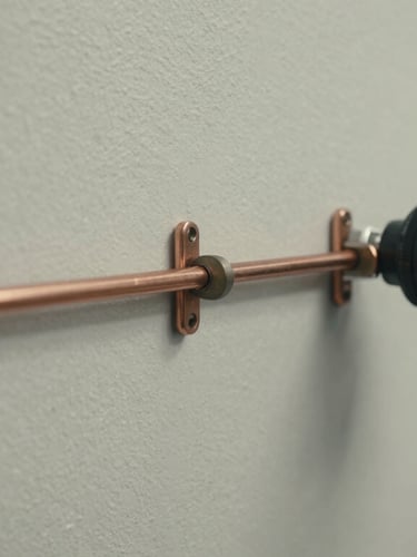 Gros plan technique de liaisons frigorifiques en cuivre parfaitement isolées et fixées au cordeau le long d'un mur extérieur propre