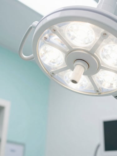 Close-up of modern dental sterilization equipment under bright clinical light, with a blurred background of a clean clinic interior, soft white and teal tones.