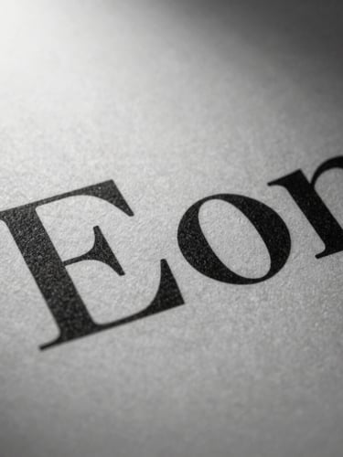 Extreme close-up of high-contrast serif typography printed on textured heavy paper, dramatic side light, deep ink shadows, editorial studio photography