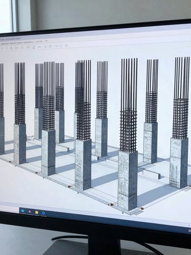 Close-up of a structural engineer's monitor displaying a complex 3D BIM model of steel rebar reinforcement inside concrete columns, sharp focus, cool blue tone
