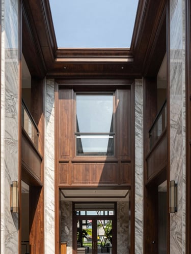 Symmetrical architectural shot of a luxury residential interior, high ceilings, premium wood and marble finishes, flooded with natural daylight, 35mm