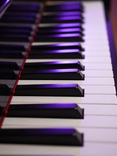 Macro shot of grand piano keys reflecting deep purple studio LEDs, low-key atmospheric lighting, symmetrical composition