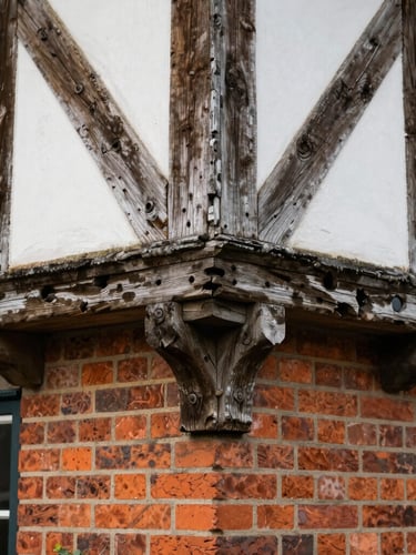 Close-up detail of historic timber joints and clean brickwork on a restored English estate, soft diffused daylight, eye-level perspective.