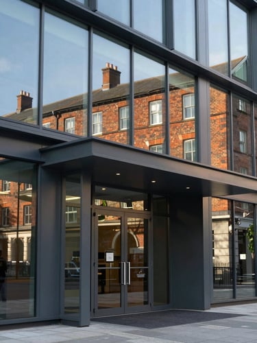 Close-up of a modern office park entrance in the Midlands, clean glass panels reflecting historic brickwork, sharp afternoon lines.