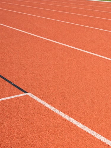 Close-up architectural shot of interlocking PP sports tiles, bright crisp stadium floodlights reflecting off the textured orange surface, sharp straight-on angle showing precision joints.