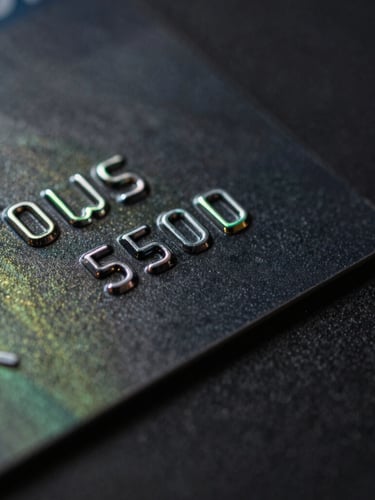 Macro close-up of a premium black metal credit card edge, neon green ambient reflections, dark background, technical aesthetic.
