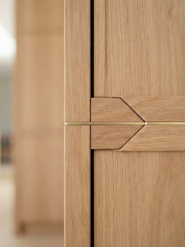 Close-up of seamless wood joinery with soft gold accents, bright natural morning light, architectural straight-on shot, shallow depth of field