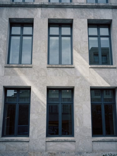 Tight architectural crop of a modern limestone courthouse facade, sharp directional window shadows, cool overcast daylight, 35mm film photography.