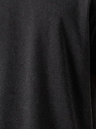 Close-up of premium fabric texture on a dark grey t-shirt, highlighting precise stitching and high-quality weave, moody studio lighting