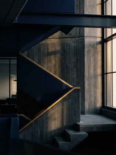 Abstract geometric architectural lines of a modern concrete building, sharp shadows, deep navy and gold tones, 35mm