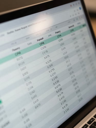 Extreme close-up of a laptop screen showing a multi-column acquisition funnel spreadsheet, rows of CPA and LTV figures visible, cool office fluorescent lighting reflecting off the screen surface, shot tight from above-left angle, numbers sharp and readable