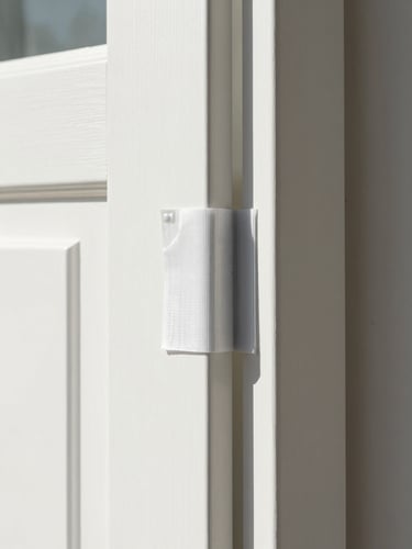 Tight macro shot of clean modern interior door sealed with professional dust-barrier plastic zipper containment, bright natural daylight, high contrast.