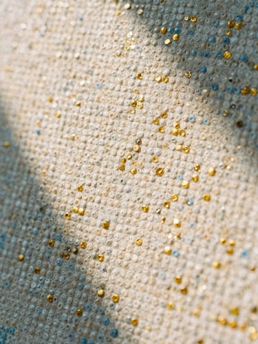 Extreme close-up macro photography of a pointillist canvas showing thousands of tiny, precise paint dots of warm alabaster, champagne gold, and soft blue blending optically, natural afternoon sunlight, medium format film