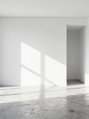 Minimalist high-key interior of a modern Kuala Lumpur apartment, pristine polished concrete floors, clean white walls, sharp daylight casting graphic shadows.