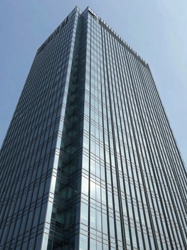 Sleek modern corporate office tower facade in Gurgaon, sharp architectural angles, bright natural daylight reflecting off glass panels, 35mm photography.