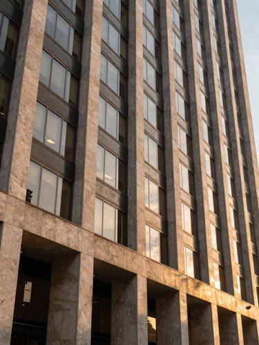 Wide-angle side-lit view of a modern architectural facade in São Paulo's financial district, sharp stone lines and tinted glass reflecting golden hour light, clean negative space.