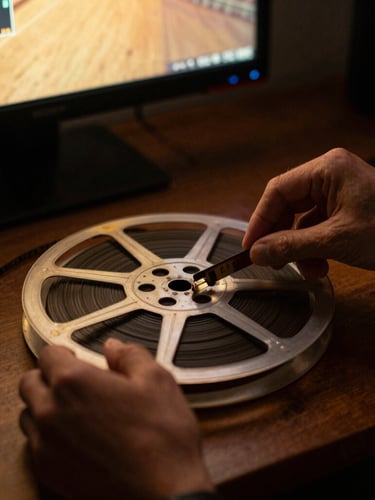 Close-up of hands meticulously restoring a vintage film reel on a modern digital workstation, warm ambient screen glow, high contrast, cinematic, 35mm.