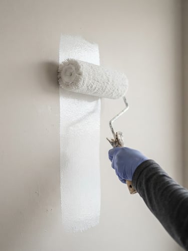Close-up of a clean paint roller applying white paint to a smooth wall, bright natural overcast daylight, high detail, 35mm lens