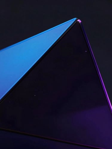 Macro close-up of abstract dark glass geometric shapes refracting electric blue and deep purple neon edge-lights, clean dark studio setting