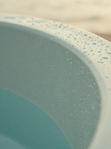 Extreme close-up of a seamless curved acrylic spa corner, water droplets clinging to the polished teal surface, soft overcast daylight highlighting the premium material texture
