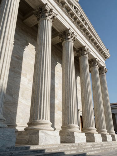 A dramatic low-angle shot of neoclassical marble courthouse columns, sharp side-lighting casting deep shadows, architectural wide angle, crisp alabaster tones.