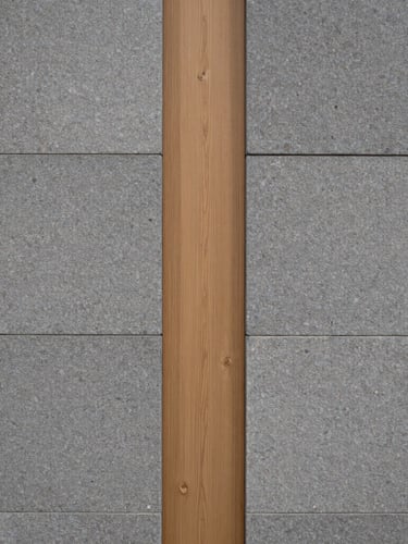 Close-up architectural detail of a modern limestone wall meeting a warm light oak wood panel, soft side lighting, minimalist Scandinavian design.