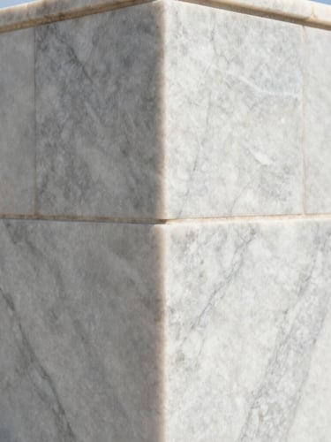 Extreme close-up of a perfectly mitered corner of large-format Calacatta marble in bright coastal daylight, showing zero-tolerance alignment and crisp details