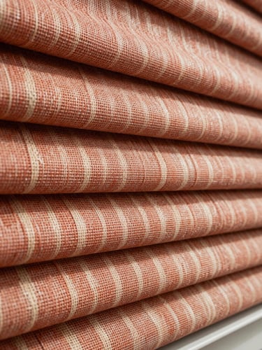 Extreme close-up of a woven roller blind fabric sample, individual threads visible in fine detail, warm terracotta and cream tones, raking north-facing daylight revealing the depth of the weave, no text, no people