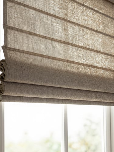 Wide environmental shot of a Roman shade in warm linen fabric, softly folded, hanging in a window with diffused morning light filtering through, empty room, no people
