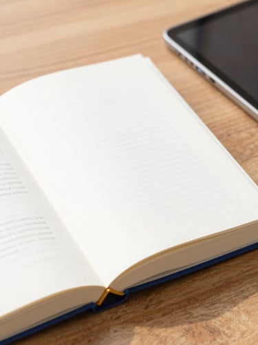 A high-quality printed book resting on a wooden table beside a modern tablet, soft natural morning light