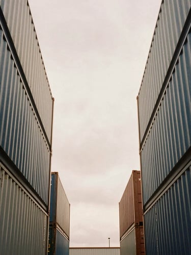 Symmetrical architectural close-up of a modern container port, soft overcast daylight, desaturated warm tones, 35mm style frame.