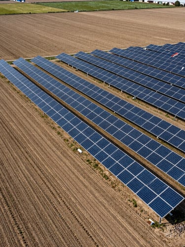 High-angle view of a modern farm layout, showing precise boundary lines between cultivated fields and a newly designated solar array on non-arable soil.