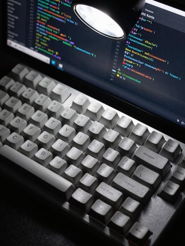 Extreme close-up overhead view of a mechanical keyboard and monitor displaying dense Android Kotlin code, studio flash lighting from above, sharp focus on key caps and code syntax, monochromatic tones, no human hands visible