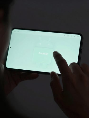 Over-the-shoulder shot of a hand interacting naturally with an Android screen, highlighting reachability with soft ambient light reflecting off the glass surface, dark theme