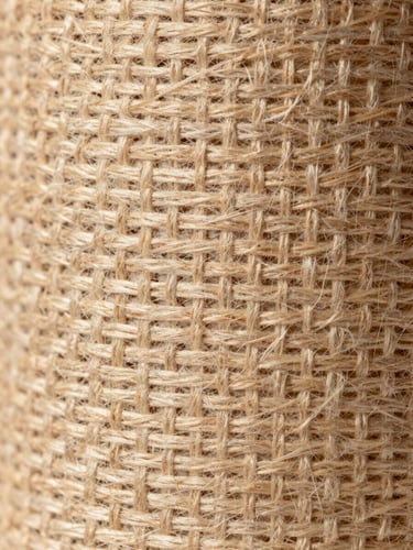 Macro close-up of heavy woven industrial textile fibers, warm daylight highlighting the structural grid of the weave, architectural and clean.