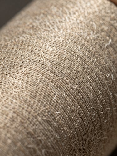 Macro close-up of textured industrial textiles, natural warm daylight highlighting the weave, clean editorial composition.