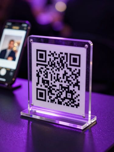 Close-up of a sleek acrylic QR code stand on a high-top table at a dimly lit event, neon violet backlighting reflecting off the surface, a smartphone screen in the background showing an instant photo gallery.