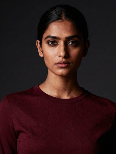 High-fashion editorial portrait of an Indian female model, dramatic studio lighting, rich burgundy and deep black tones, sharp focus, 35mm