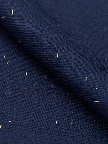 Close-up macro shot of premium navy blue fabric showing precise twill weave pattern, gold metallic fibers woven subtly throughout, professional studio lighting.