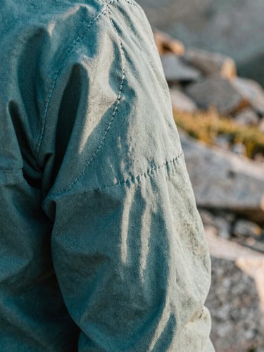 Close up of heavy-weight canvas apparel stitching, rugged texture, outdoor natural light, shallow depth of field