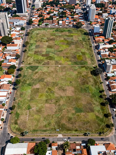 Aerial photograph of a flat urban land plot in Brazil, clearly demarcated boundaries, surrounding streets and neighborhood visible, clean natural daylight, no people