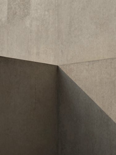 Minimalist editorial photograph of concrete architectural planes intersecting under soft diffused daylight, gentle shadows, muted slate and coffee tones, tactile textures.