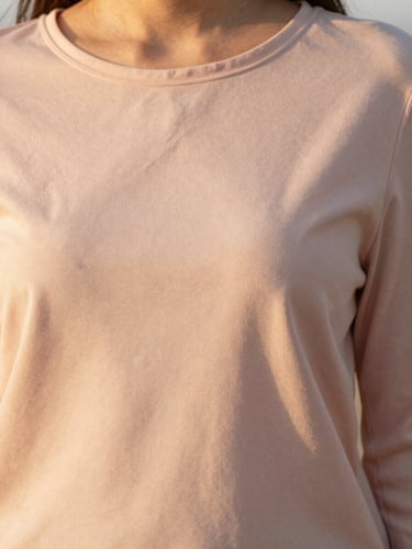 Editorial close-up of a pastel pink modest blouse drape, soft golden-hour daylight, 35mm.