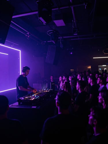 moody event photography, high-contrast neon and ambient lighting, deep indigo and electric violet tones, wide-angle cinematic lens, a DJ performing in a dark, atmospheric club, silhouetted against a neon-lit stage, with a crowd in motion, right-aligned, bleeding to the edge.