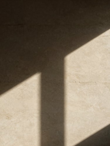Dramatic high-contrast study of architectural shadows and light on a warm alabaster concrete wall, minimalist composition, medium format film style.