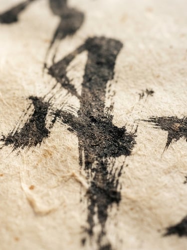 Macro close-up of dark ink brushstrokes on textured, aged warm cream Xuan paper, soft natural side-light showing fibrous paper texture, elegant and silent, 35mm photography