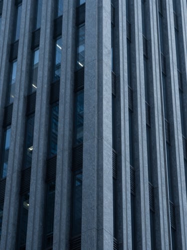 Macro shot of architectural lines of a modern corporate skyscraper, deep blue and slate tones, cool diffused light, 35mm